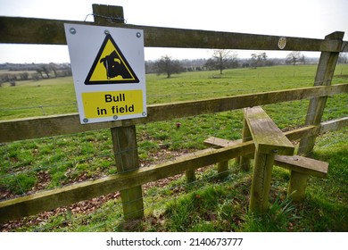 View of a wooden fence stile on a public footpath with a generic 'bull in field' sign