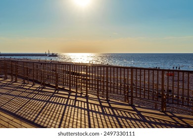 View from the wooden observation deck towards the sea. Sunset. Shadows of steel balustrades. Leba, Baltic sea, Poland - Powered by Shutterstock