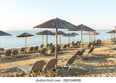 View Of Wooden Umbrellas And Sun Loungers On A Mediterranean Beach