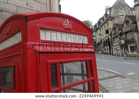 View of the word 'Telephone' on a traditional vintage red British phone box on a street in an English city