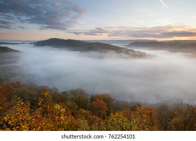 View Of Wye Valley From Symonds Yat Rock Viewpoint. Autumn Mist Fills Valley At Sunrise. 