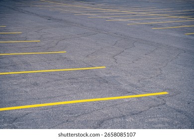 View of yellow lines on empty outdoor parking lot.
