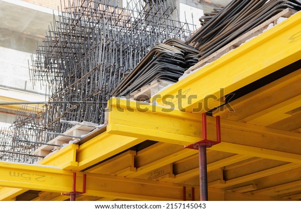 View\
of yellow wooden support beams, ready to install steel\
reinforcement on the formwork. Construction of buildings and\
structures made of monolithic reinforced\
concrete.