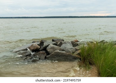 A View Of The York River In Gloucester, Virginia. Rocks, Grass, Beach