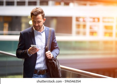 View of a Young attractive business man using smartphone