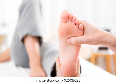 View Of A Young Attractive Physiotherapist Doing Reflexology On A Patient Feet