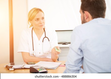 View Of A Young Attractive Woman Doctor Taking Health Insurance Card