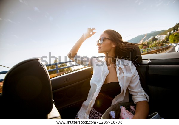 View at young attractive woman drive in cabriolet
at seaside