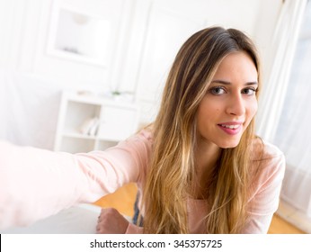 View Of A Young Attractive Woman Taking Selfie At Home 