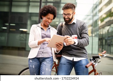 View at young business people talking and smiling outdoors - Powered by Shutterstock