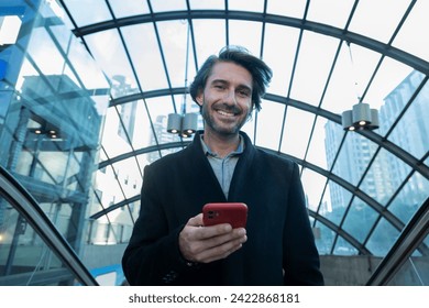 View of young man using a smartphone at indoor space with a blurred view landscape in the background. High quality photo. Texting on the phone.  - Powered by Shutterstock