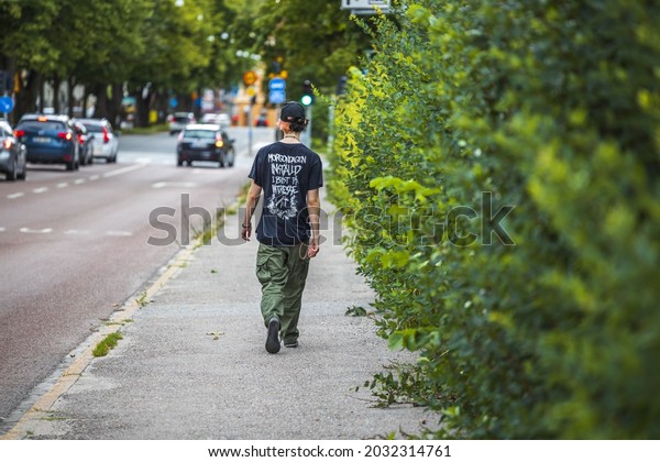View of young man walking along road on\
summer day. Sweden. Uppsala.\
08.25.2021.