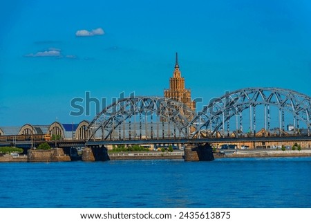 view of the zeppelin hangars and the academy of sciences building next to a steel railway bridge in the Latvian capital Riga..