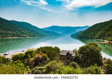 View of the Zhinvali Reservoir, a picturesque artificial reservoir in Georgia.Blue sky with white clouds.The reservoir is armed with mountains.Mountains are reflected in the water.