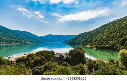View of the Zhinvali Reservoir, a picturesque artificial reservoir in Georgia.Blue sky with white clouds.The reservoir is armed with mountains.Mountains are reflected in the water.Copy space.