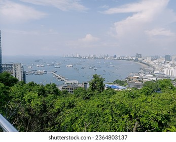 Viewed from above, the picture showcases Pattaya Beach, adorned with numerous buildings, hotels, and restaurants, all bustling with activity. - Shutterstock ID 2364803137