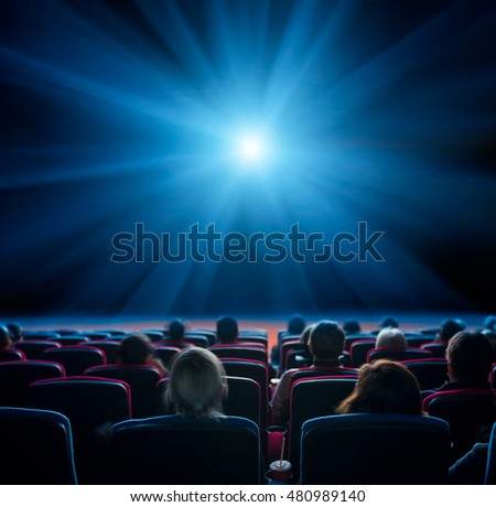 viewers watch blue star at cinema, long exposure, blue glow