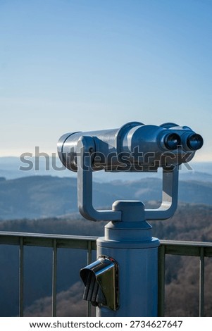 Viewing binoculars overlooking distant mountain landscape