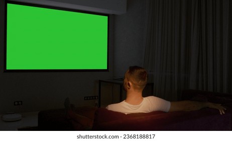 Viewing on a projector in a closed room. Media. A man looking into a green screen that is shown on a large screen. - Powered by Shutterstock