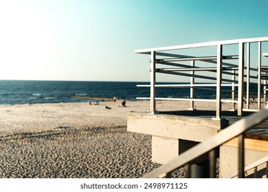Viewing platform with a protective barrier. View of the sea and sandy beach. Stainless steel balustrade