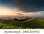 Viewpoint of Mount Eden with sky tower among illuminated city in the evening at Auckland, New Zealand