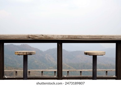 A viewpoint on the mountain with wooden fence chair and a lamp wooden house on the Wat Phra That Pha Sorn Kaew area  scenery with mist in the afternoon. - Powered by Shutterstock