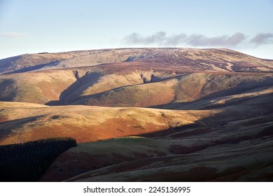 Views of The Cheviot from below the summit of Windy Gyle on a sunny winters morning in the Northumberland Cheviot mountains at sunrise, UK.