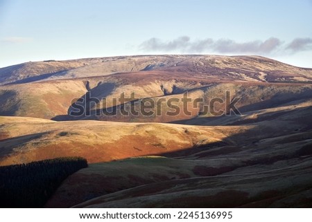 Views of The Cheviot from below the summit of Windy Gyle on a sunny winters morning in the Northumberland Cheviot mountains at sunrise, UK.