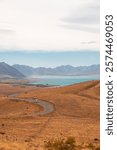 Views of Lake Tekapo and surroundings as seen from Mount John Observatory during a summer day with clear blue water and white clouds (Tekapo, South Island, New Zealand)