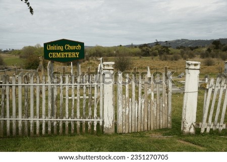 Views of wooden picket fence and gateway to Uniting Church cemetery.