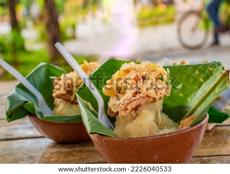The vigoron typical food of Granada, Nicaragua. Traditional Vigoron in banana leaves served on a wooden table. Nicaragua food concept, Close-up of two vigorones served on a wooden table