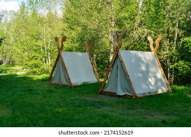 Viking camp by the river. Couple of  stylish tents on the grass. Located in the viking village. Tranditional nordic viking camping style. Sunny summer day in Estonia. High resolution image