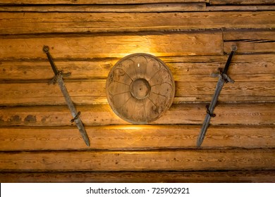 Viking Swords And Small Shield Hanging On Wooden Wall