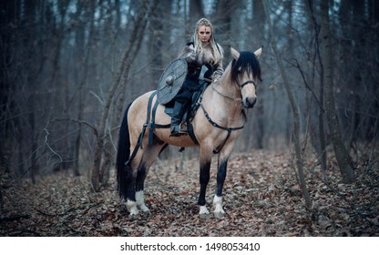 Viking warrior female ridding a horse at twilight autumn forest - Medieval movie scene
