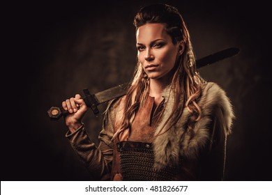 Viking woman with sword in a traditional warrior clothes.