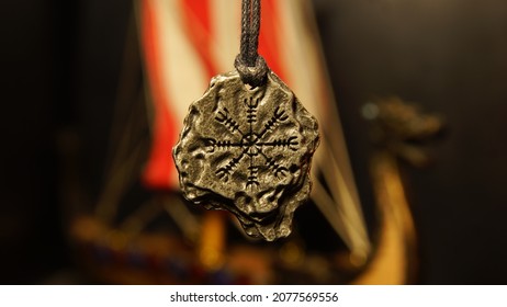 Vikings Amulet A Symbol Of Fear On The Background Of A Drakkar Model In The Dark. Mystical Background