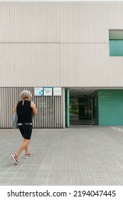 Viladecans, Catalunya, Spain - August 25, 2022: May Caucasian Woman Entering Primary Care Medical Center. Health Care Concept.