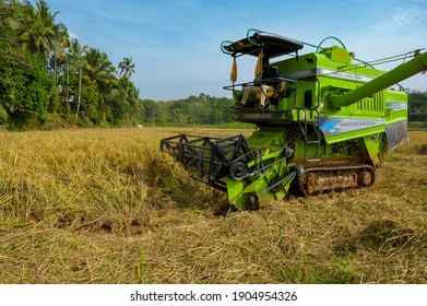 Vilayur, Palakkad, Kerala, South India - January 9, 2021 : Farmer Uses Machine To Harvest Rice On Paddy Field.