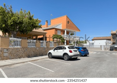 Villa for vacation on sea. Suburb home building Exterior. Beach holiday home. Fence and facade of house. Houses Exterior at mediterranean coast. Car on parking at home. Street with pavement road. 