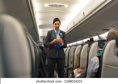 Villafranca, Italy - November 16 2018: A Stewardess On Board An Airplane Holding An Oxygen Mask, Pre-flight Procedure.