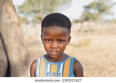 village african child standing in the yard late afternoon at sunset  - Shutterstock ID 2395517627