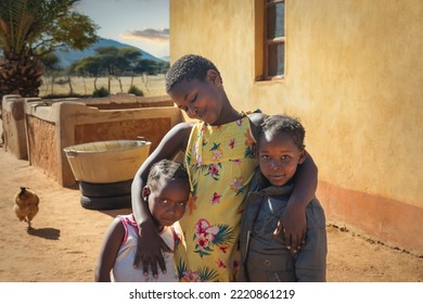 Village African Family Portrait Of Three Loving Sisters In The Yard At Sunset