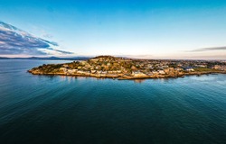 Village of Dalkey, Co. Dublin, Ireland - March 2021: Aerial drone panoramic still image. View of Dalkey village at golden sunrise., a Nature Photo by Michal Ficel