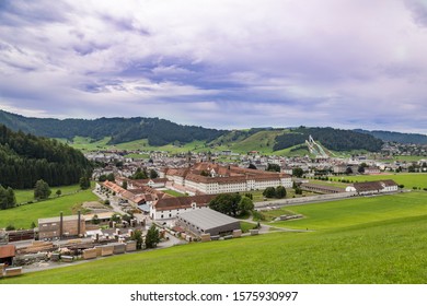 Village Einsiedeln. Canton of Schwyz. Switzerland. View of center of town and Benedictine monastery ( Einsiedeln Abbey) surrounded by green hills. 