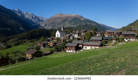 Village Ernen with parish church of St. Georg, in background the mountains of Wannenhorn group and the Risihorn. Ernen is a village in the Valais Alps in Switzerland. - Powered by Shutterstock