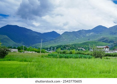 The village at the foot of the mountain has blue skies, white clouds, and natural scenery. High quality photo - Powered by Shutterstock