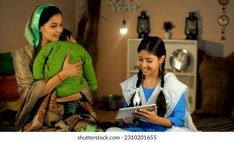 A village mother and a young schoolgirl in uniform using a digital tablet together. A happy family of a rural household spending quality time together in a traditional kitchen - village home, domes. - Shutterstock ID 2310201655