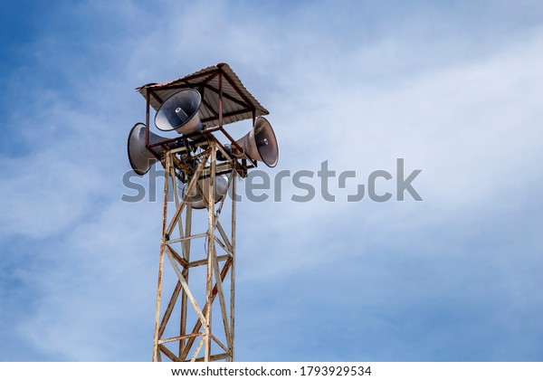 Village news speaker tower on blue sky\
background, horn\
speaker