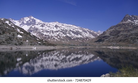 Village On The Splügen Pass With Reflection From The Mountain In The Lake