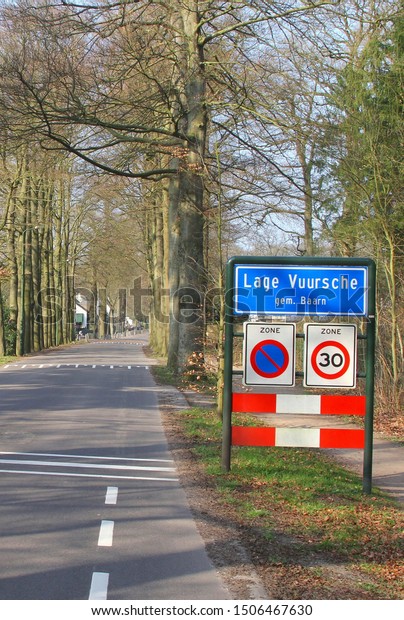 Village sign of Lage Vuursche, community of\
Baarn, at forest road in rural landscape, Netherlands. Here lives\
princess Beatrix at castle\
Drakensteyn